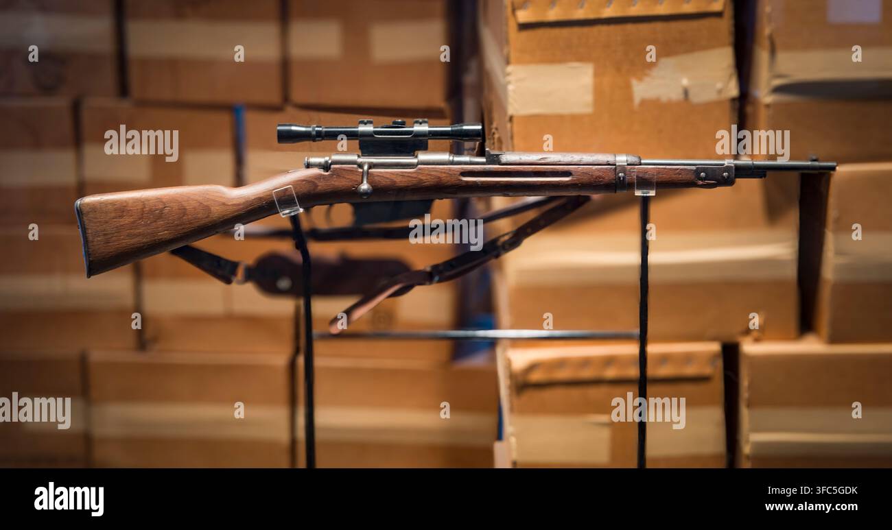 Eine Duplikatkopie des 6,5 x 52 mm italienischen Carcano M91/38 Repetiergewehrs mit Bolzenverschluss, ausgestattet mit einem 4x Hollywood-Marken-Zielfernrohr, das von Lee Harvey Oswald, dem mutmaßlichen Mörder von Präsident John F. Kennedy am 22. November 1963 in Dallas, Texas, verwendet wurde. Dieses Gewehr wird im Lagerraum im sechsten Stock des Texas School Book Depository ausgestellt, wo Oswald einen Aussichtspunkt über dem Dealey Plaza fand, entlang dessen Kennedy, der texanische Gouverneur John Connally und ihre Ehefrauen in einer Autokolonne fuhren. Heute Sixth Floor Museum genannt, wird der Ort von der Dallas County Historical Foundation betrieben. Das Originalgewehr und ein Stockfoto