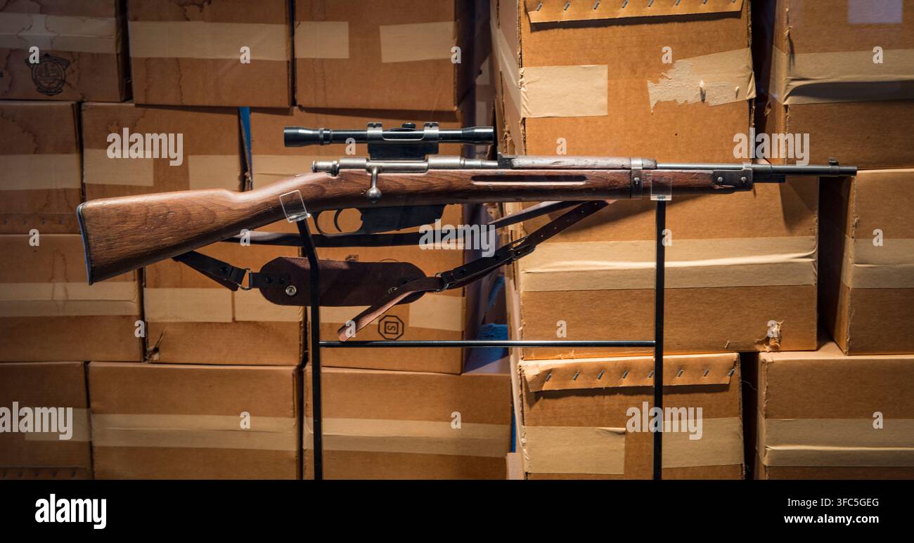 Eine Duplikatkopie des 6,5 x 52 mm italienischen Carcano M91/38 Repetiergewehrs mit Bolzenverschluss, ausgestattet mit einem 4x Hollywood-Marken-Zielfernrohr, das von Lee Harvey Oswald, dem mutmaßlichen Mörder von Präsident John F. Kennedy am 22. November 1963 in Dallas, Texas, verwendet wurde. Dieses Gewehr wird im Lagerraum im sechsten Stock des Texas School Book Depository ausgestellt, wo Oswald einen Aussichtspunkt über dem Dealey Plaza fand, entlang dessen Kennedy, der texanische Gouverneur John Connally und ihre Ehefrauen in einer Autokolonne fuhren. Heute Sixth Floor Museum genannt, wird der Ort von der Dallas County Historical Foundation betrieben. Das Originalgewehr und ein Stockfoto