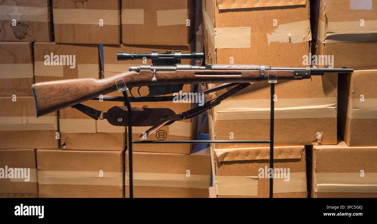 Eine Duplikatkopie des 6,5 x 52 mm italienischen Carcano M91/38 Repetiergewehrs mit Bolzenverschluss, ausgestattet mit einem 4x Hollywood-Marken-Zielfernrohr, das von Lee Harvey Oswald, dem mutmaßlichen Mörder von Präsident John F. Kennedy am 22. November 1963 in Dallas, Texas, verwendet wurde. Dieses Gewehr wird im Lagerraum im sechsten Stock des Texas School Book Depository ausgestellt, wo Oswald einen Aussichtspunkt über dem Dealey Plaza fand, entlang dessen Kennedy, der texanische Gouverneur John Connally und ihre Ehefrauen in einer Autokolonne fuhren. Heute Sixth Floor Museum genannt, wird der Ort von der Dallas County Historical Foundation betrieben. Das Originalgewehr und ein Stockfoto