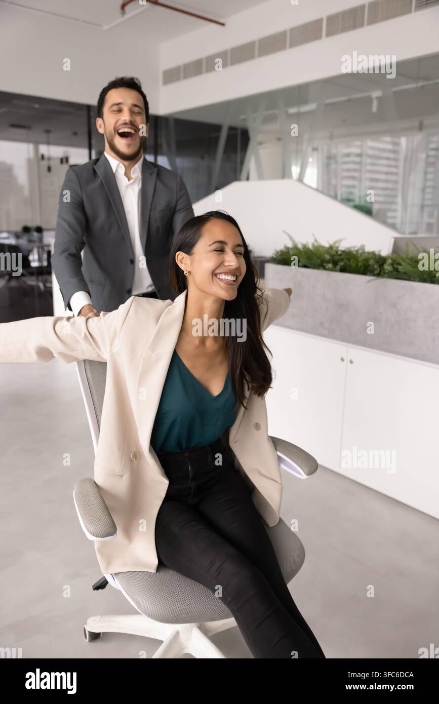 Verschiedene Kollegen genießen eine verspielte Feier im Firmenbüro Stockfoto