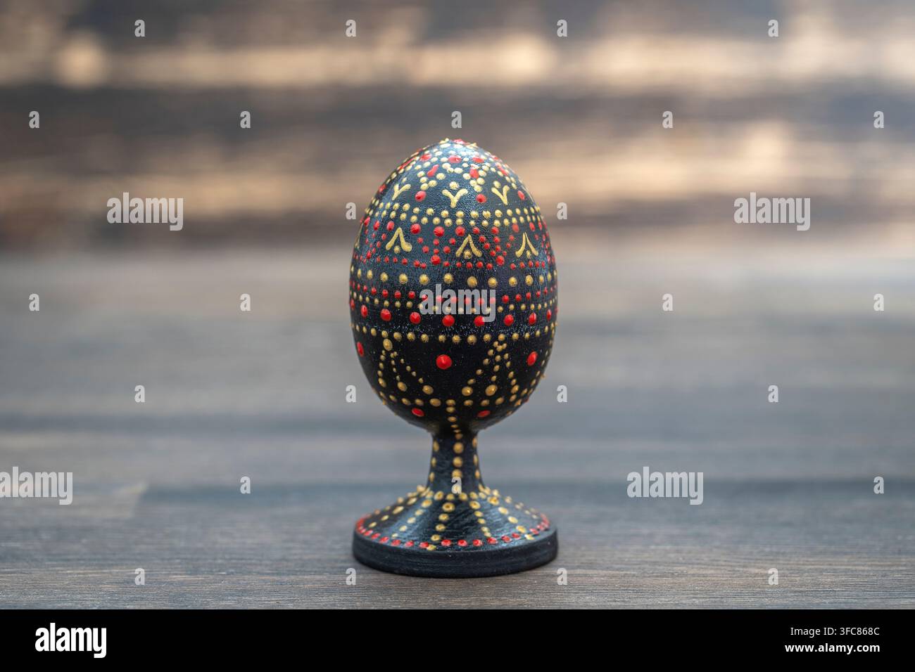 Farbenfrohes handgefertigtes Osterei auf Holzuntergrund. Handbemalte Ostereier mit Acrylfarben, Handarbeit, Punktmalerei, Nahaufnahme, Ukraine Stockfoto