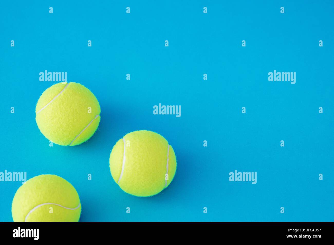 Tennisbälle angeordnet auf hellblauem Hintergrund mit Kopierraum. Minimales Sportkonzept. Kreative Tennisballidee. Tennis-Ästhetik. Stockfoto