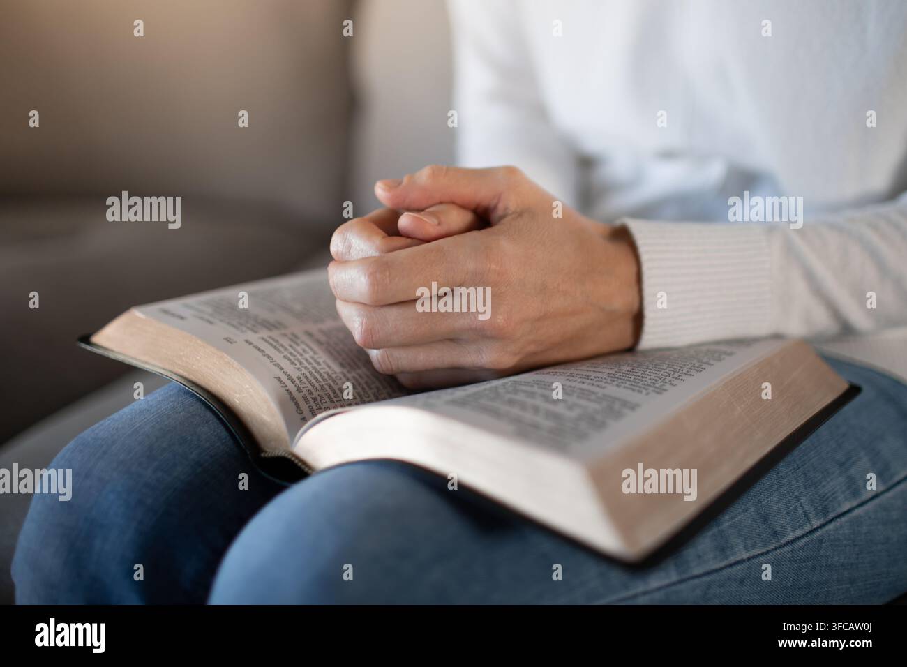Frau hält eine Bibel und spricht ein Gebet. Stockfoto