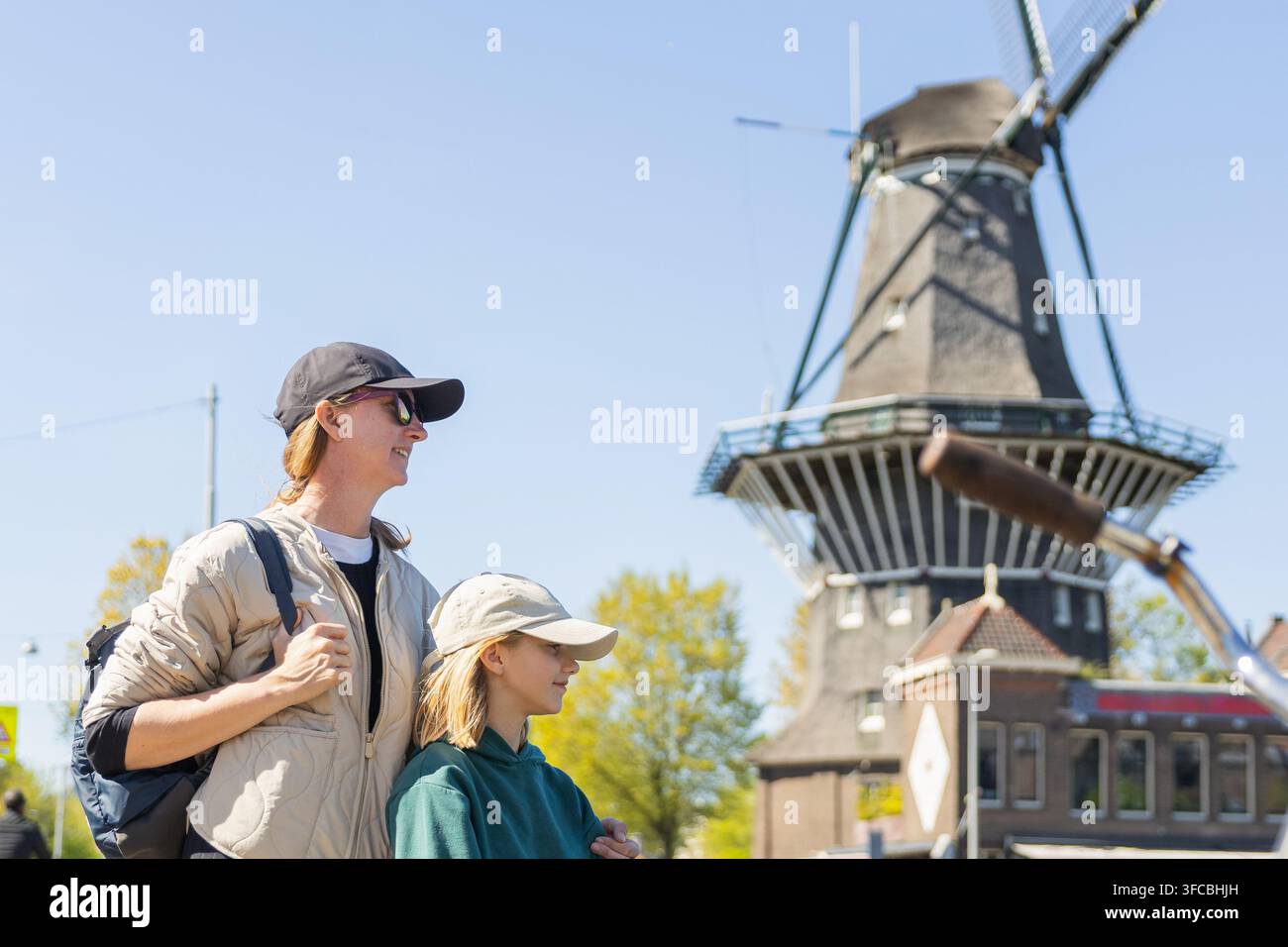 Mutter und Tochter besuchen eine Windmühle in den Niederlanden während ihres gemeinsamen Europaurlaubs. Sie genießen ihre Zeit im Freien. Stockfoto