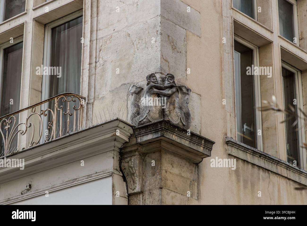 Zwei ineinander verschlungene Steinfiguren von Tritonen schmücken die Ecke des Maison des Deux Sirènes, einem Haus aus dem späten 16. Jahrhundert in der Rue Saint-Michel in Nancy, Grand Est, Frankreich. Herzog Nicolas-François von Lothringen und seine Frau Claude flohen in der Nacht zum 1. April 1634 verkleidet aus dem Haus, um ihrer politisch unpopulären Ehe zu entkommen. Stockfoto