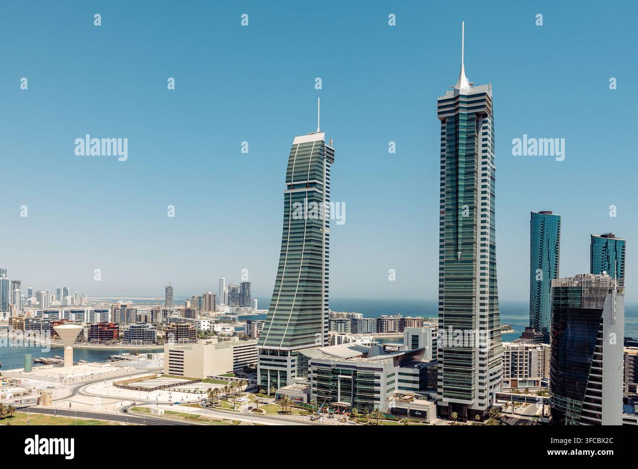Luftbild der Bahrain World Trade Center-Türme mit ikonischem segelähnlichem Design und Windturbinen, vor der Skyline und den Küstengewässern von Man Stockfoto