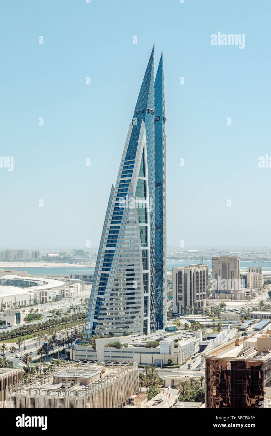 Luftbild des ikonischen Bahrain World Trade Center mit seinen markanten Zwillingstürmen und Windturbinen, die sich über der modernen städtischen Skyline in Manama erheben Stockfoto