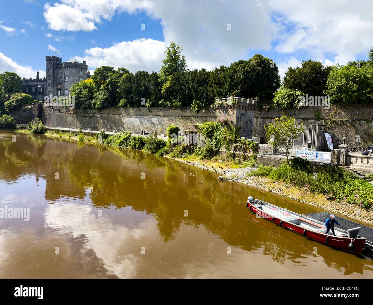 Ansicht des Kilkenny Schlosses, des Flusses Nore und eines Bootes von der John's Bridge aus, Kilkenny, Irland - Smartphone-aufgenommenes Stockfoto