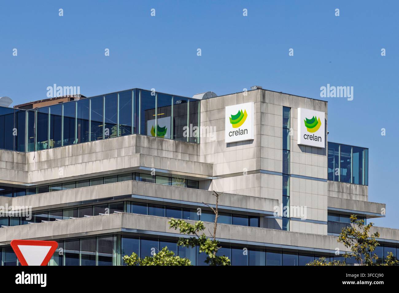 Antwerpen, Belgien - 14. August 2026: Ein Bürogebäude zeigt das Logo der Crelan Bank vor einem klaren blauen Himmel. Stockfoto