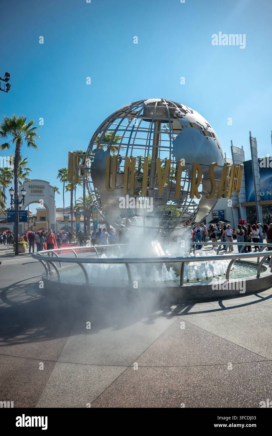 Erdekugel und Eingang von Universal Studios Hollywood mit Brunnen, Besuchern und Palmen am Eingang des Freizeitparks in Universal City, Kalifornien, USA Stockfoto