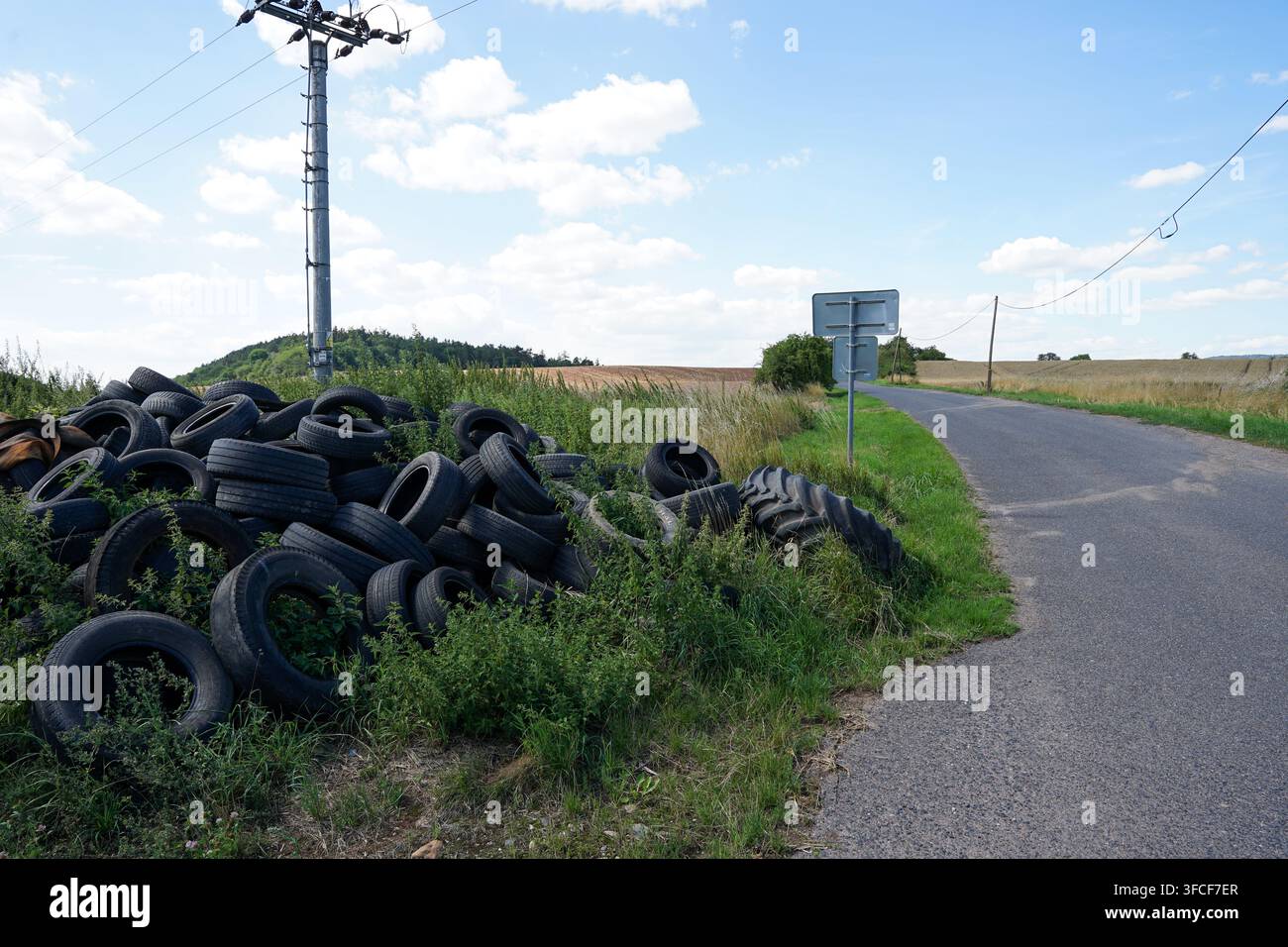 Illegale Entsorgungsstelle für gebrauchte Autoreifen in der Nähe einer Landstraße, Tschechien Stockfoto