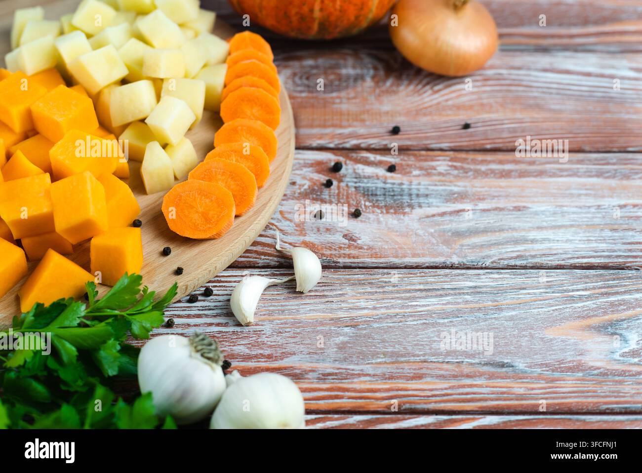Zutaten für Kürbissuppe. Geschnittene saisonale Gemüse: Kürbis, Kartoffeln und Karotten. Kopierraum. Stockfoto