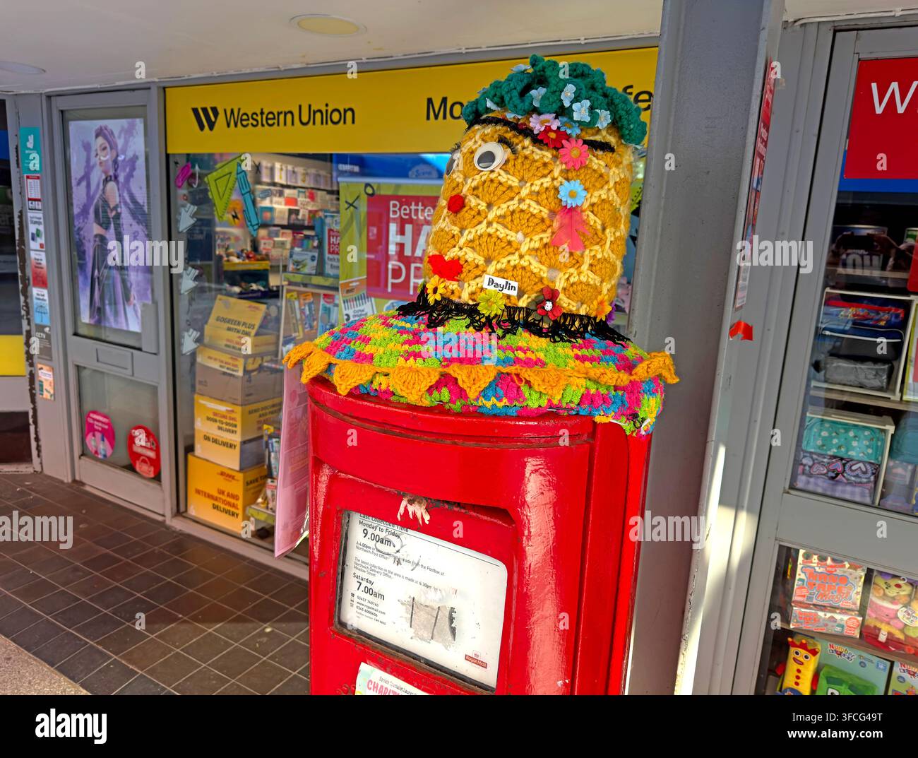 Roter Royal Mail Briefkasten, der für das Northwich Pina Colada Festival 2026 mit einer gestrickten Ananas geschmückt ist Stockfoto
