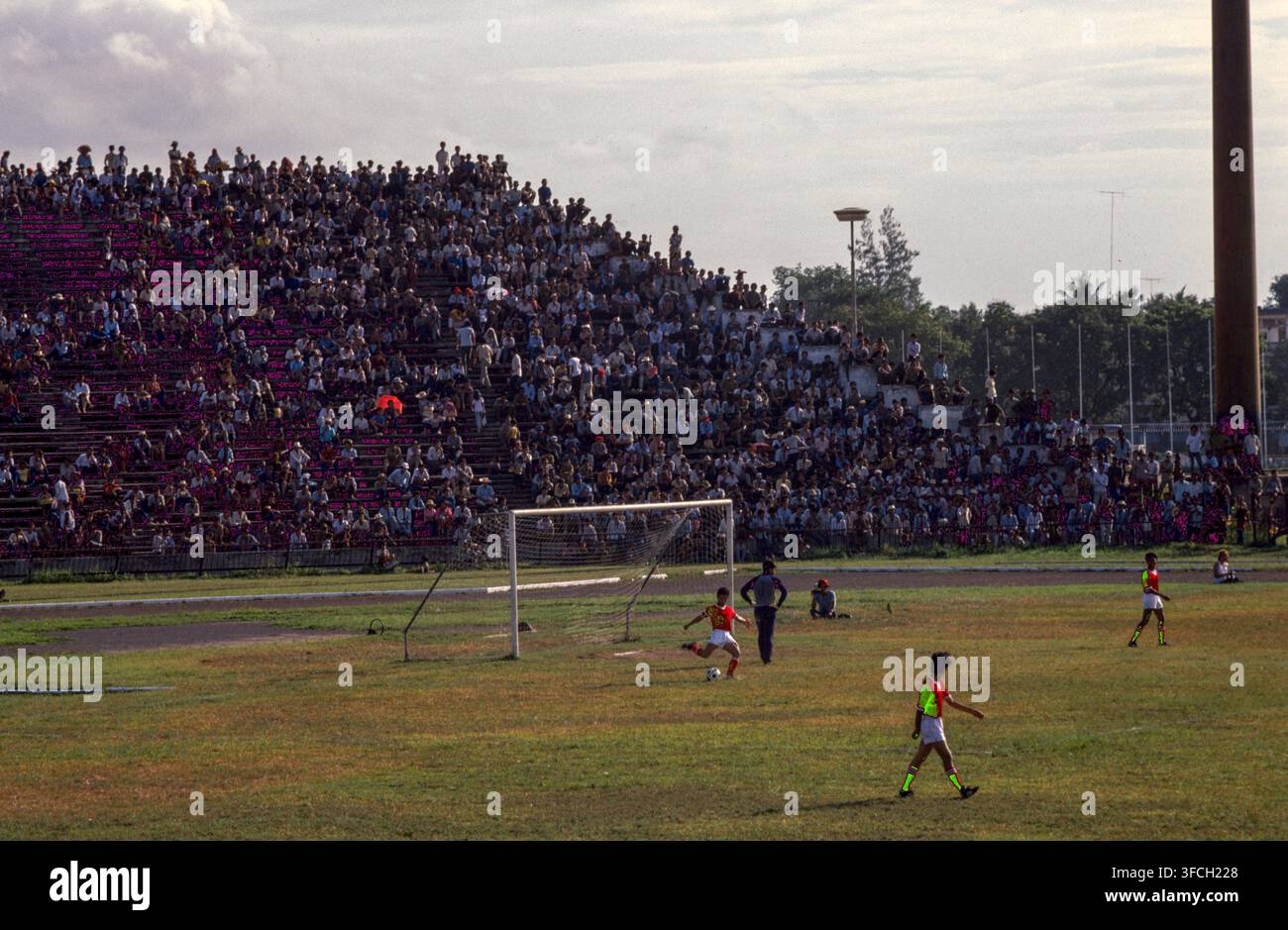 Leute, die ein Fußballspiel in Phnom Penh, Kambodscha, 1987 ansehen. Stockfoto