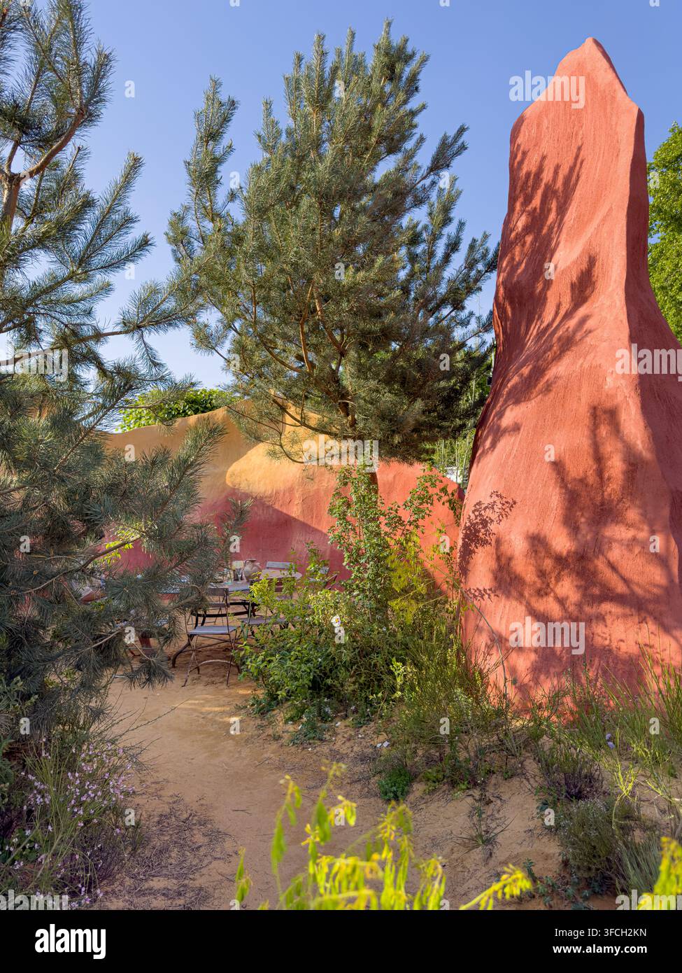 Hohe ockerfarbene Klippen und Kiefern im The Project Giving Back Garden von James Basson auf der RHS Chelsea 2026. Stockfoto