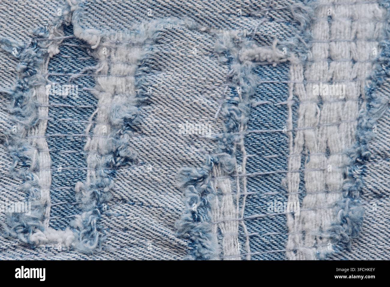 Extrem Makro-Aufnahme stark beschädigten Denimstoffs, der komplexe zerrissene Fäden und die gewebte Struktur zeigt Stockfoto
