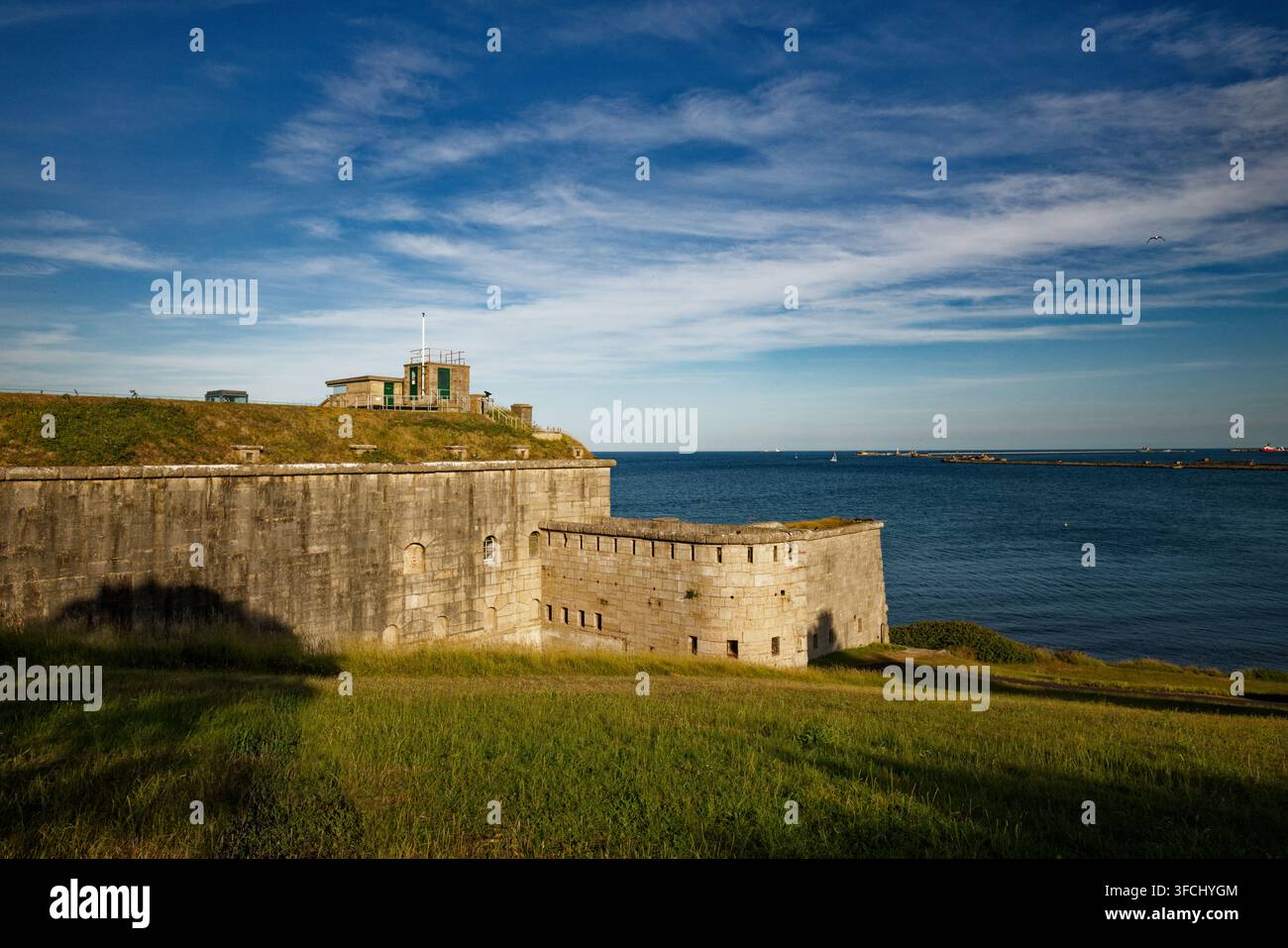 Ein Bastion und Aussichtsposten überblickt ein ruhiges blaues Meer von einem grasbewachsenen Küstenpark aus, Nothe Fort, Weymouth, Dorset, England. Stockfoto