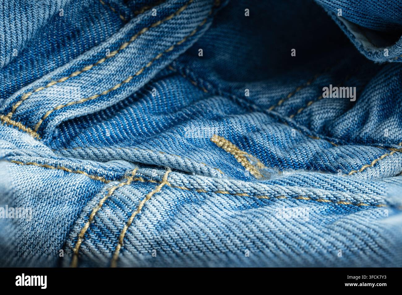 Blaues Denimgewebe, das Details der Nähte und der Textur zeigt Stockfoto