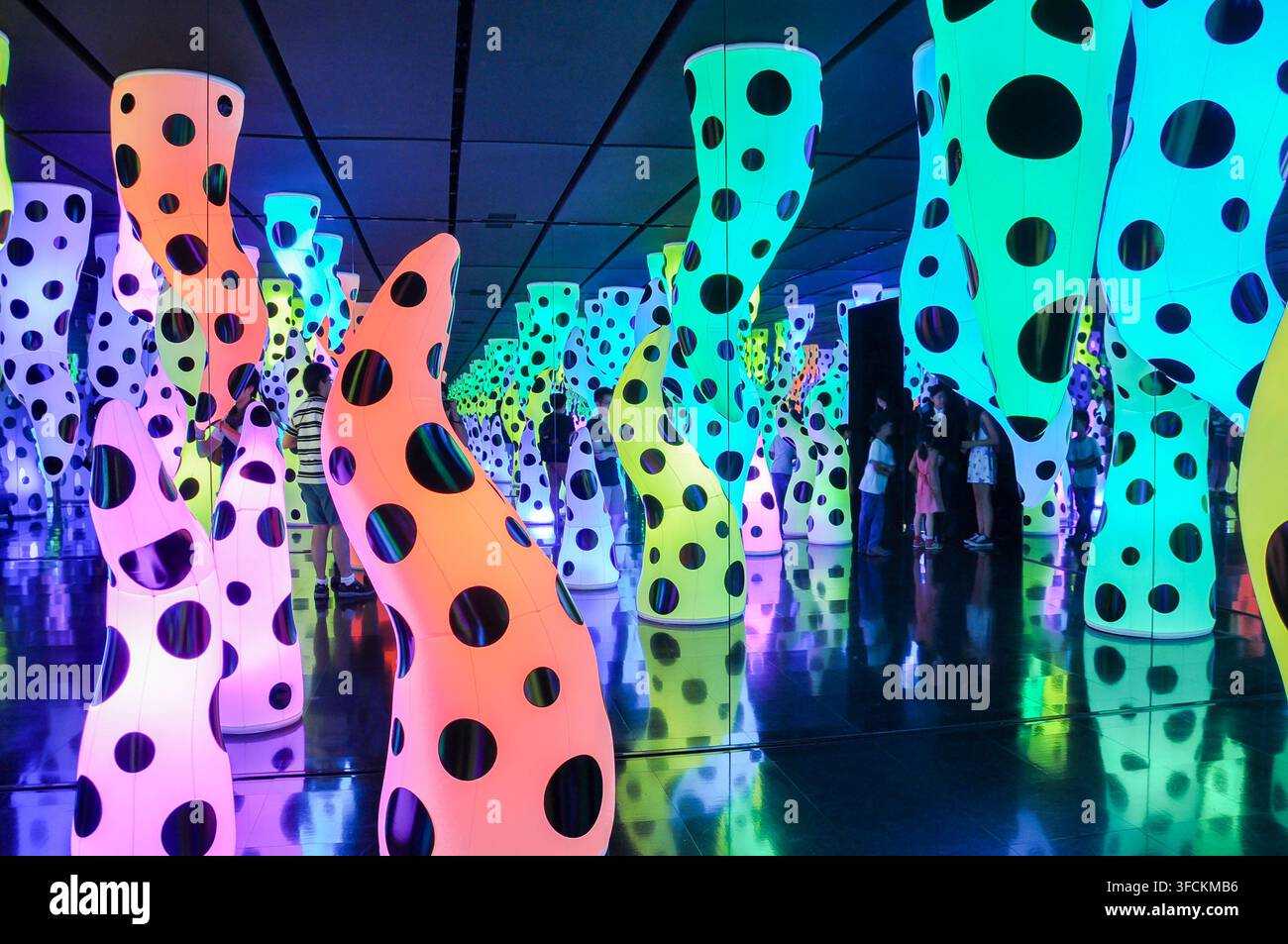 Tokio, Japan, 08 10 2013: Menschen erleben farbenfrohe, leuchtende, gepunktete Skulpturen in einer immersiven Kunstinstallation Stockfoto
