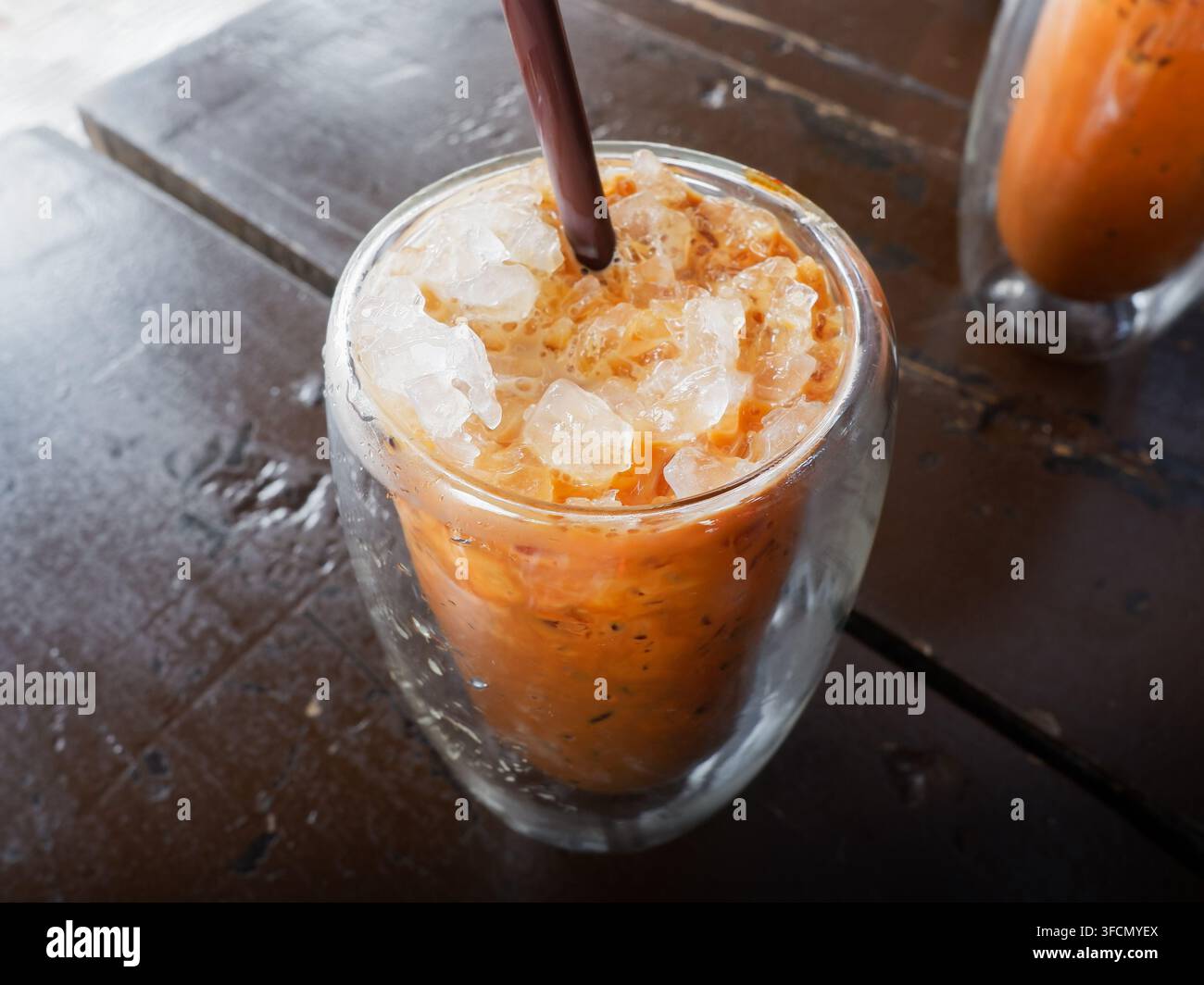 Eisgekühlter thailändischer Milchtee gemischt mit Kaffee, serviert in einer doppelwandigen Tasse Stockfoto