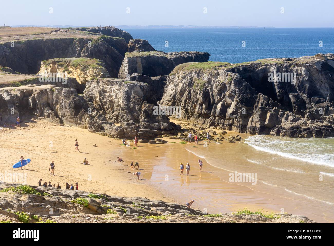 Urlauber an einer kleinen Sandbucht, die von schroffen Klippen umgeben ist, an der Cote Sauvage, Halbinsel Quiberon, Bretagne, Frankreich. Stockfoto