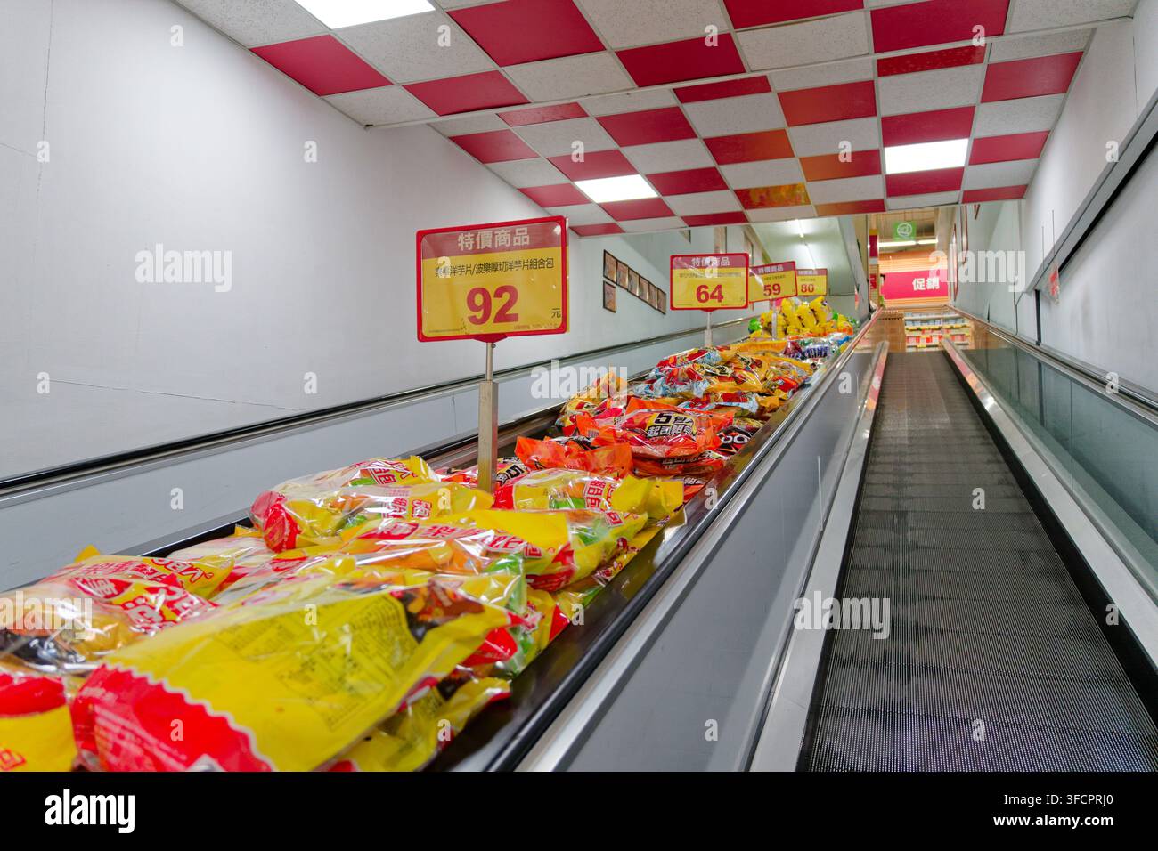 Taoyuan, Taiwan – 27. Feb. 2026: Snack-Pakete füllen den Rolltreppenraum zwischen den Stockwerken in einem taiwanesischen Großhandelsgeschäft. Stockfoto