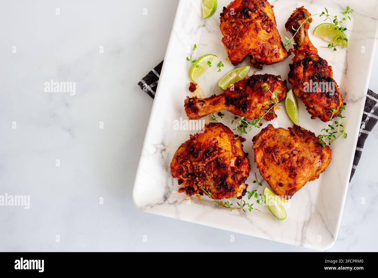 Scharfe gebratene Hähnchen Drumsticks und Oberschenkel mit Limette Stockfoto
