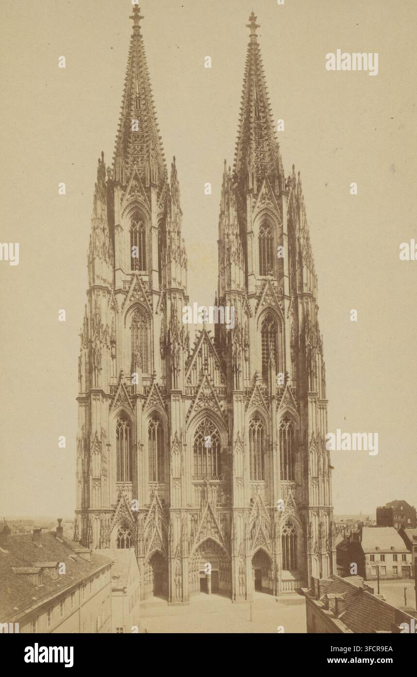 Köln. Kathedralkloster, Fotografie, 1850 - 1880, Fotograf, Papier, Albuminprint, Albumendruck, Höhe 140 mm x Breite 100 mm, Höhe 170 mm x Breite 110 mm, Nordrhein-Westfalen, Köln, Kölner Dom., Eine sepiafarbene Fotografie, die die vordere Fassade einer großen gotischen Kathedrale mit zwei hohen Türmen zeigt, die von verzierten Turmhelmen gekrönt sind, spitzbogigen Arkaden, mit Maßwerk gefüllten Fenstern und dekorativen Fialen; der mittlere Abschnitt zeigt einen großen gewölbten Eingang mit aufwendiger Steinmetzarbeit und flankierenden kleineren spitzbogigen Portalen, mehrere vertikale Strebebögen und geschichtete Arkaden erheben sich an den Türmen, und Stockfoto