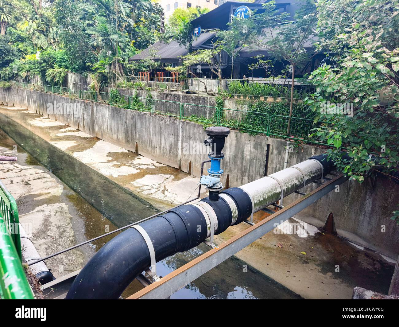 große Versorgungswasserleitung, die über einen städtischen Entwässerungskanal verläuft, funktionale Luftauslassventil (Luftventilstelle oder Luftentlastungsventil), Singapur Stockfoto