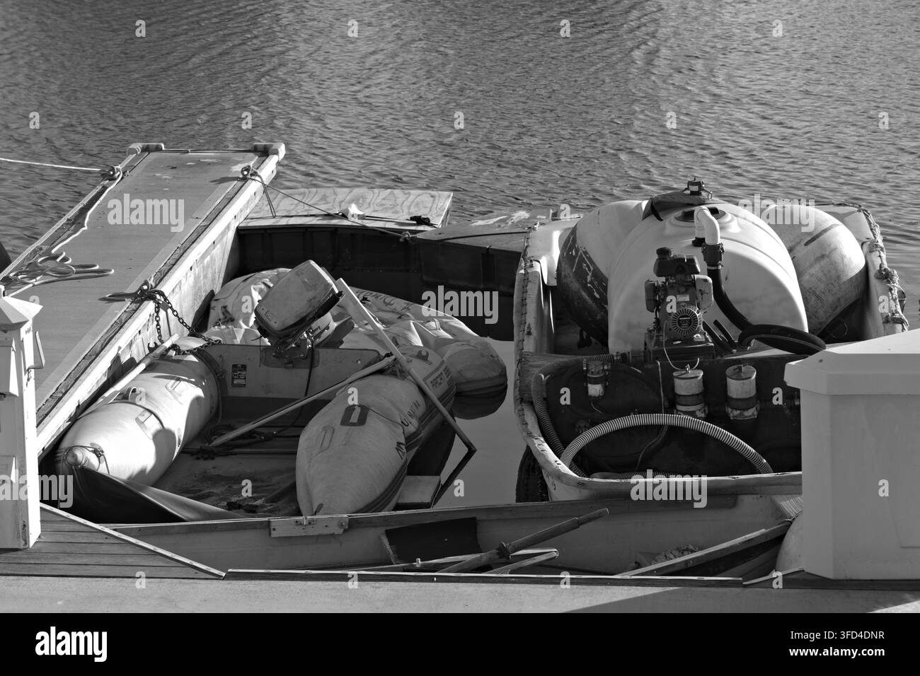 Verrottetes Boot schwimmt in der Nähe des Piers. Verwittertes Holz und Seile sind sichtbar. Verlassene Schiffe deuten auf vergessene maritime Nutzung hin. Geeignet für Themen wie Verfall, Neg Stockfoto