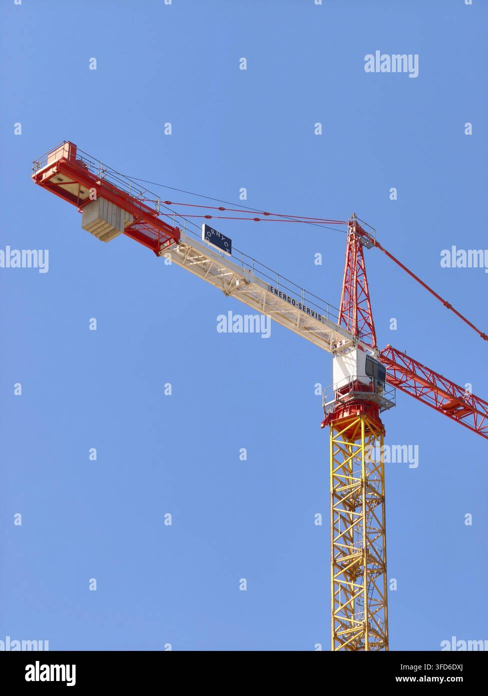 Turmdrehkran auf einer Baustelle vor einem klaren blauen Himmel. - Smartphone-aufgenommenes Stockfoto