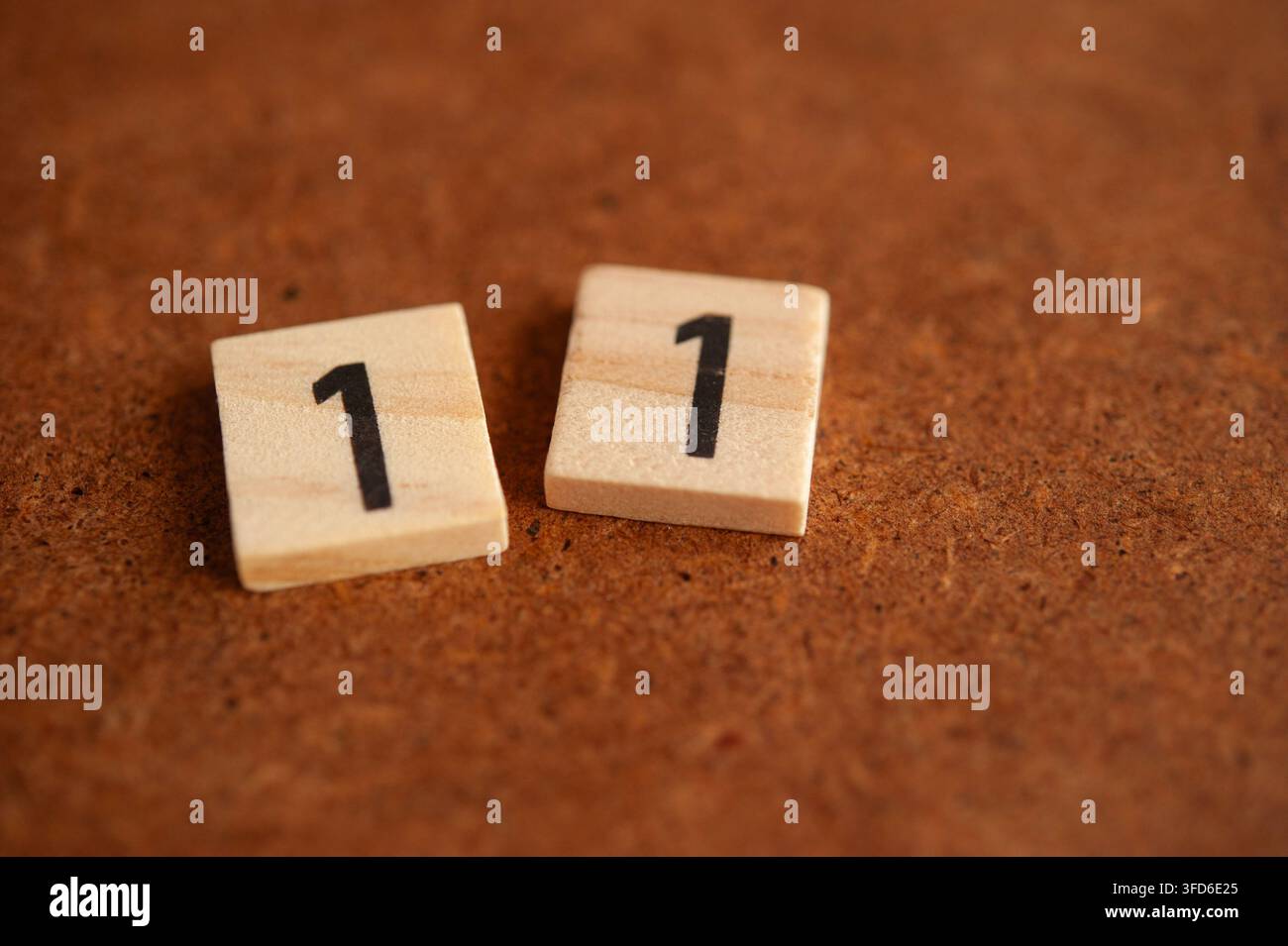 Holzfliese mit der Primzahl 11 auf einer rustikalen braunen Oberfläche, mathematisches Konzept mit Kopierraum für Bildung und Rechenfertigkeiten Stockfoto