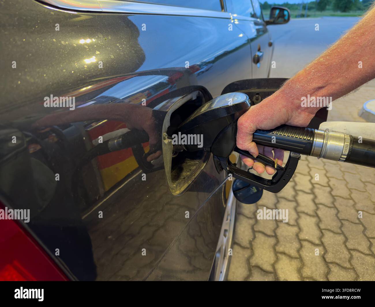 Tanken eines Autos an einer Tankstelle während der Abendstunden Stockfoto