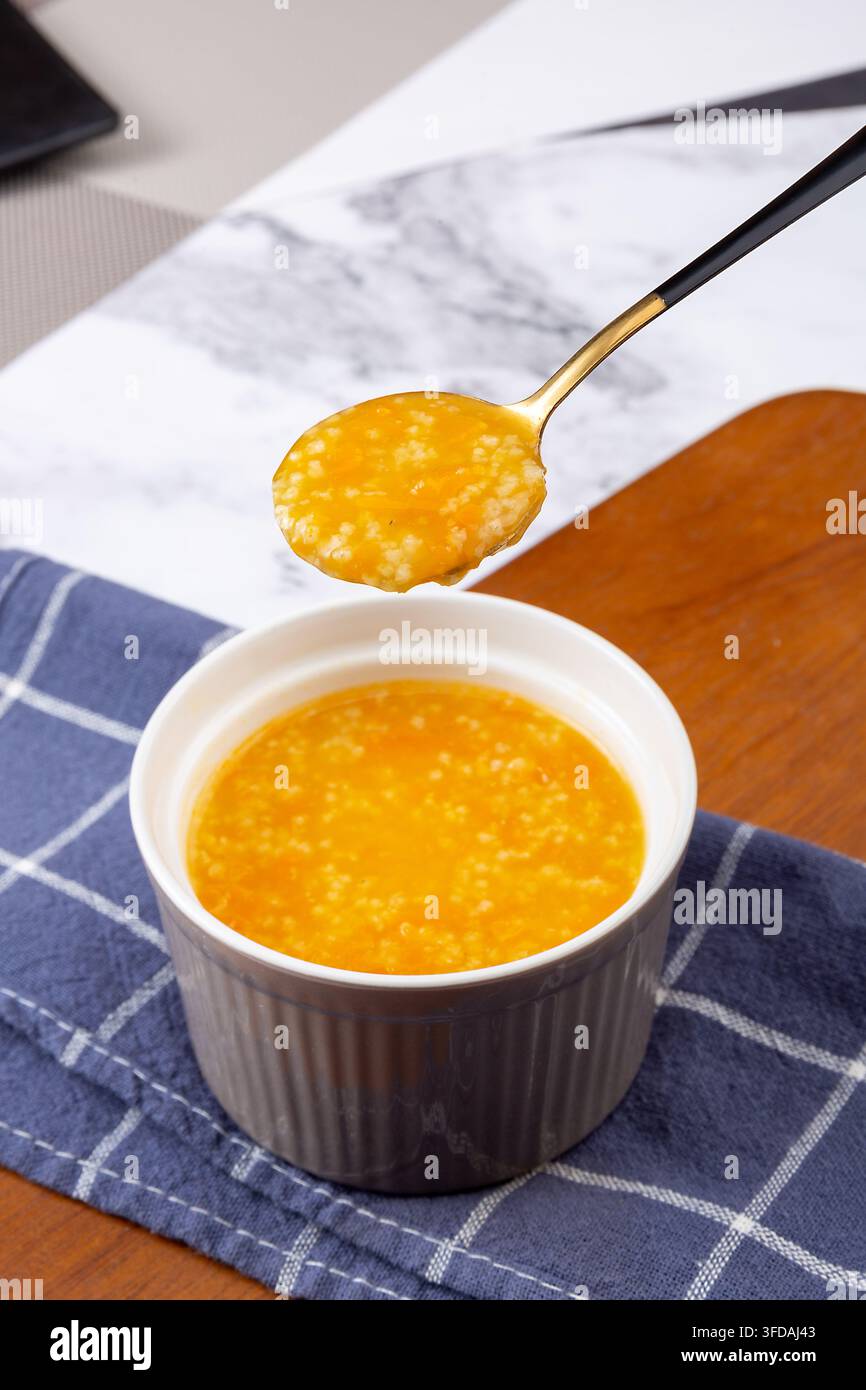 Goldener Hirse-Kürbisbrei garniert mit getrockneten Goji-Beeren Stockfoto