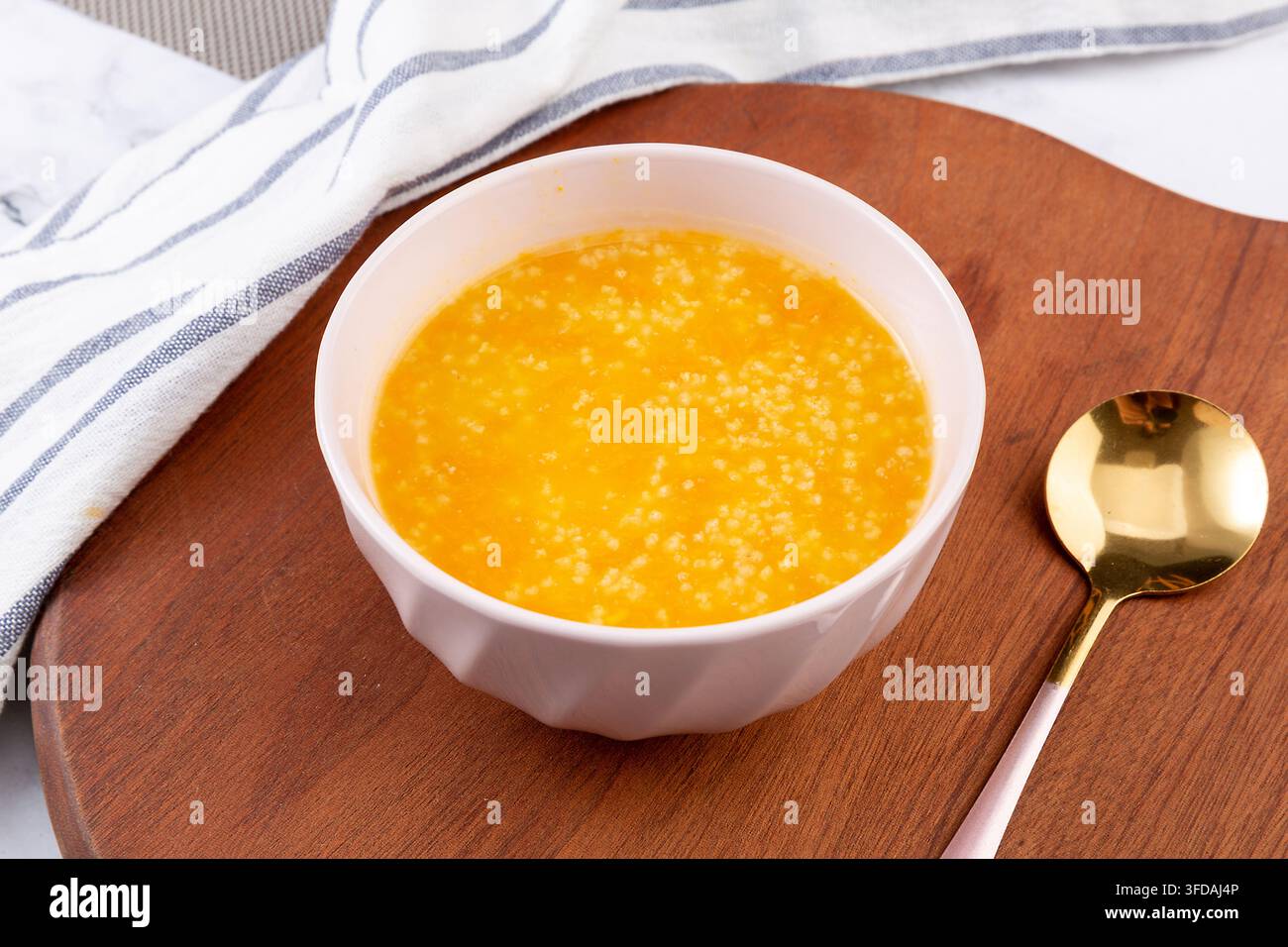 Goldener Hirse-Kürbisbrei garniert mit getrockneten Goji-Beeren Stockfoto