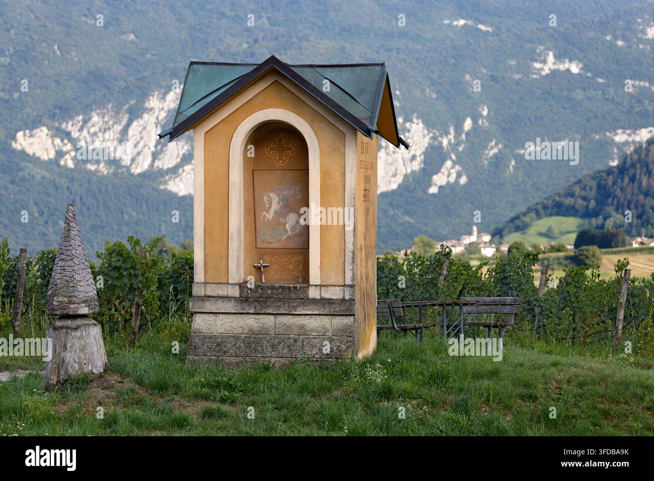 Ädikula des Heiligen Georg mitten in den Feldern von Cavrasto. Bleggio Superiore, Giudicarie, Trentino, Italien. Stockfoto