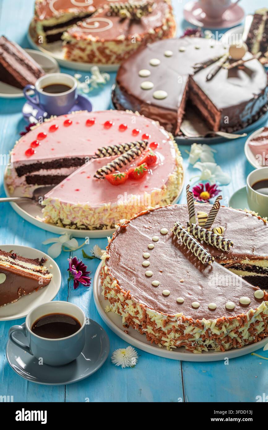 Hausgemachte Kuchen serviert mit Kaffee als frisches Dessert. Frische hausgemachte Kuchen begleitet von Tassen Kaffee. Stockfoto