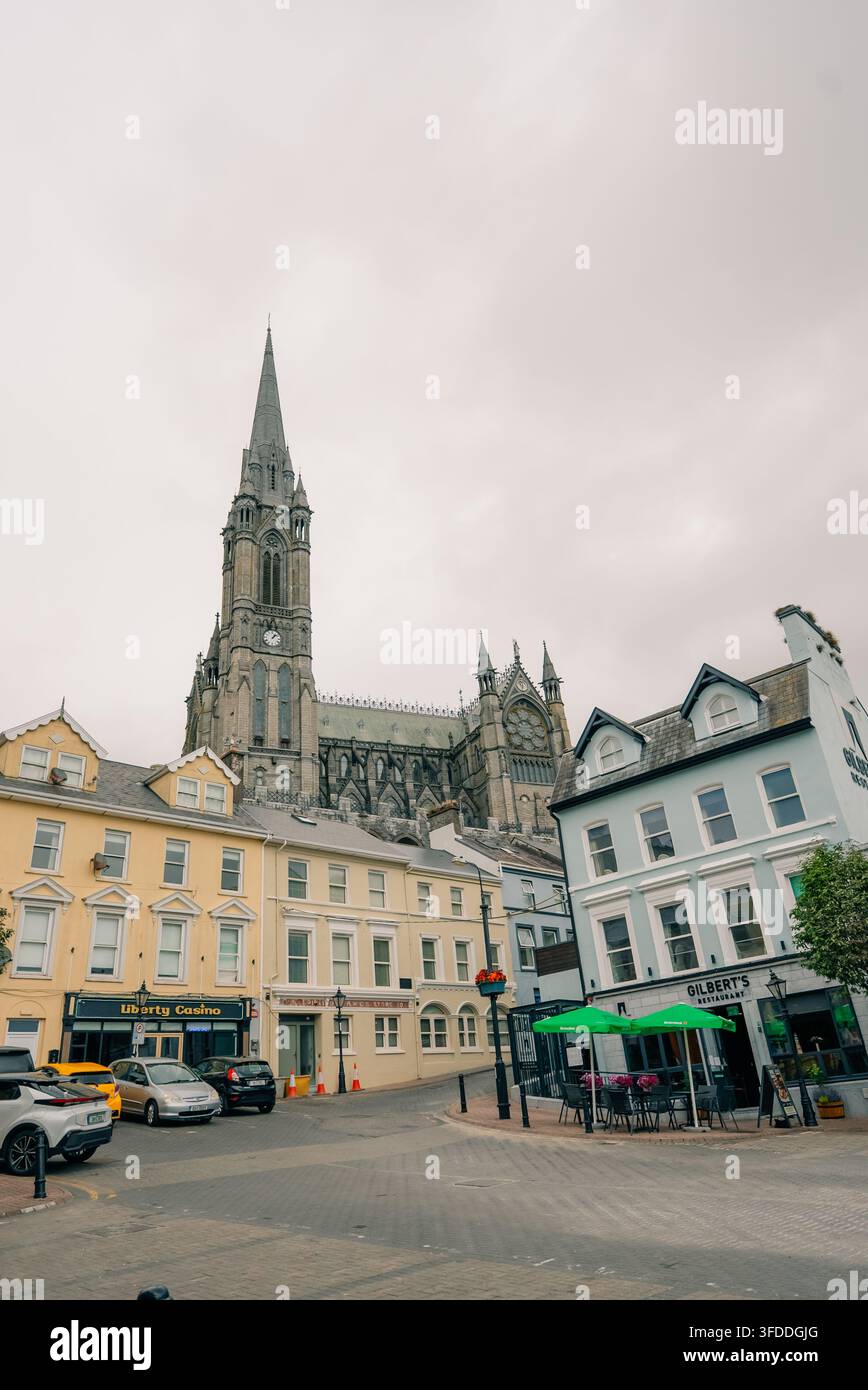 Pittoreske Küstenstadt Cobh in der Grafschaft Cork, Irland, mit der neogotischen St. Colman Kathedrale, die über den farbenfrohen Hügelhäusern und Cork Harbour aufragt Stockfoto