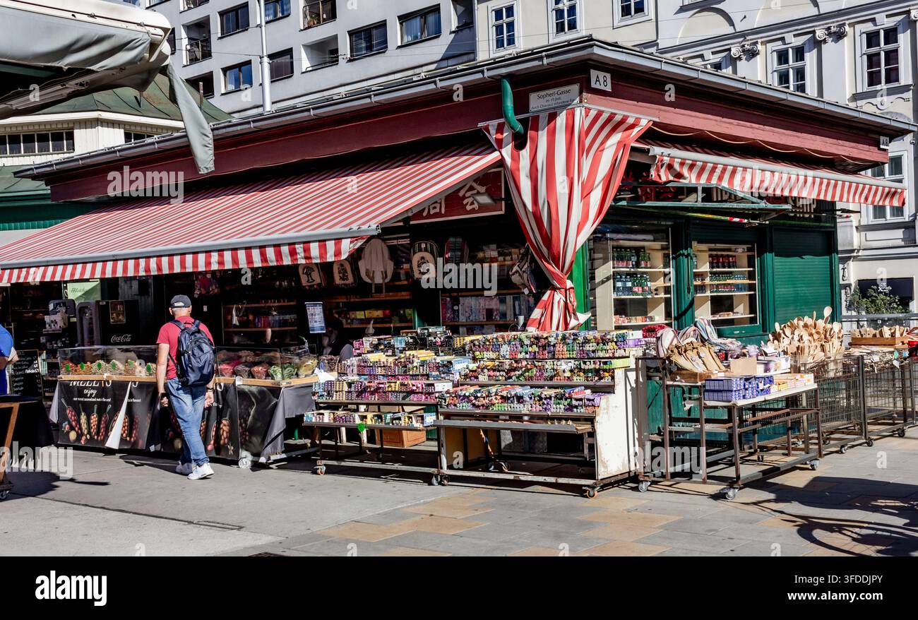 Ein traditioneller Marktstand mit gestreiften Markisen und Ausstellungsständen auf dem berühmten Naschmarkt-Freiluftlebensmittelmarkt in Wien, Österreich Stockfoto