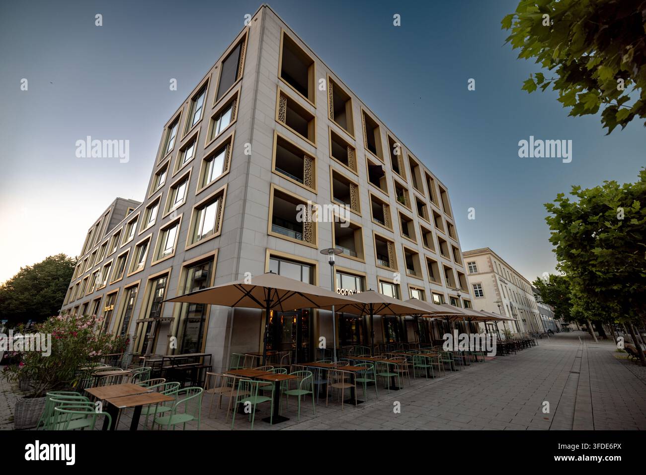 Zeitgenössisches Mixed-Use-Gebäude mit sich wiederholenden quadratischen Fensteröffnungen steht im Stadtzentrum von Hannover. Stockfoto
