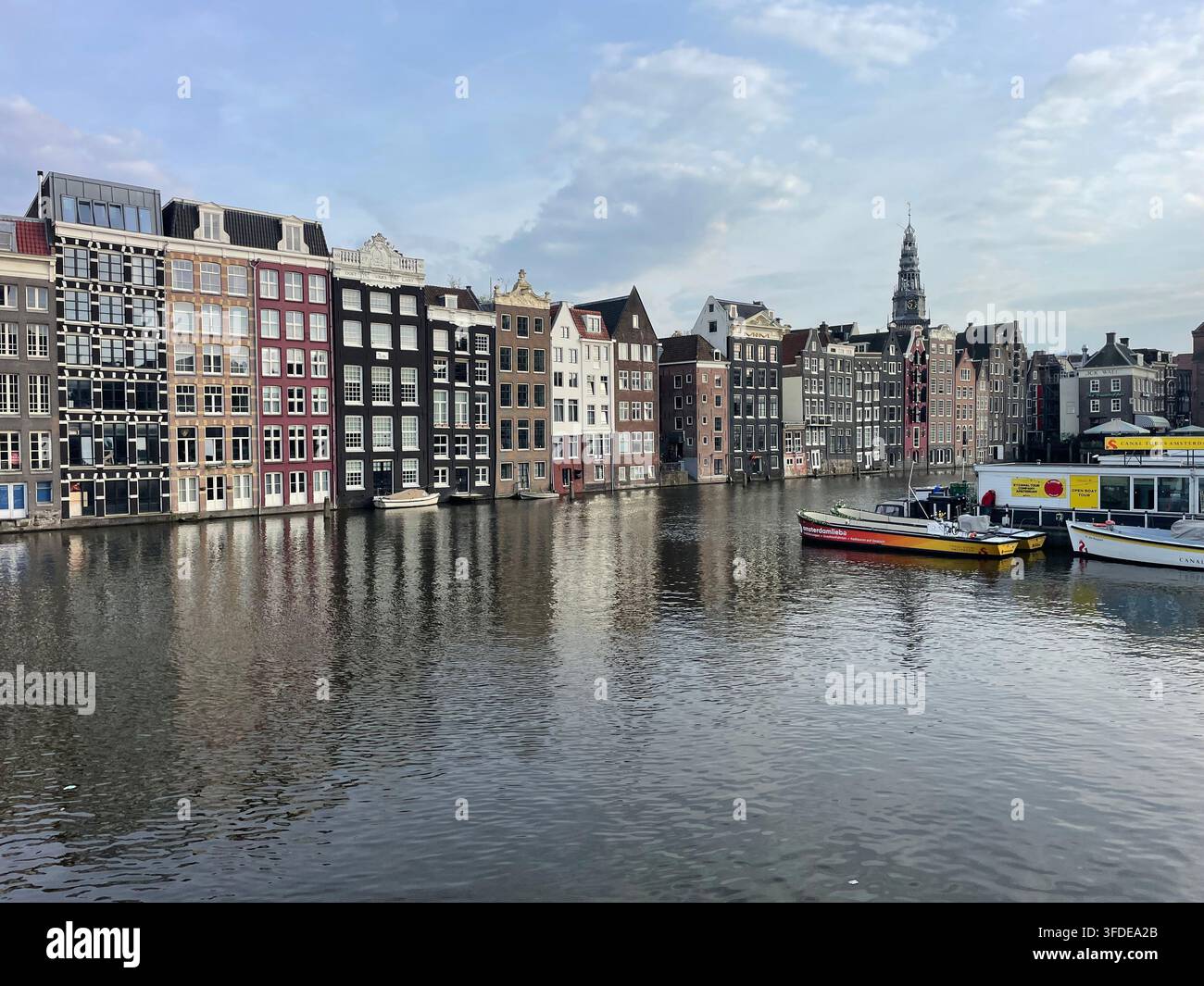 Die Häuser des Damrak-Viertels von Amsterdam spiegeln sich im Wasser des Kanals wider Stockfoto