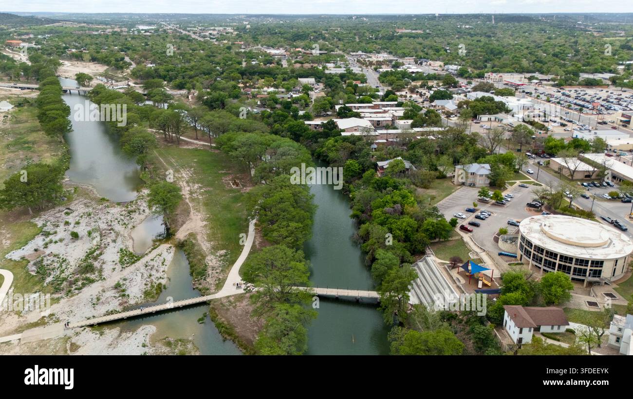 Luftbilddronensicht des Guadalupe River, Parks, Brücken und der Innenstadt von Kerrville, Texas, mit umliegenden Wohngebieten und Gewerbegebieten. Stockfoto