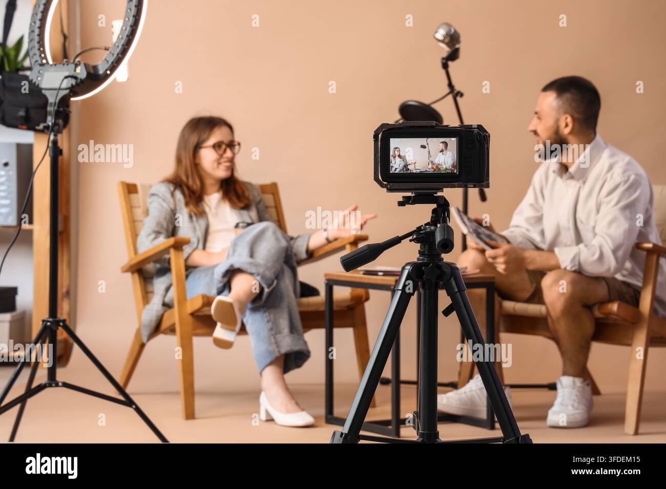 Inhaltserstellung und Podcast-Interview, professionelle Influencer nehmen eine Videokonversation in einem Studio mit Kamerausrüstung und Beleuchtungsgeräten auf Stockfoto