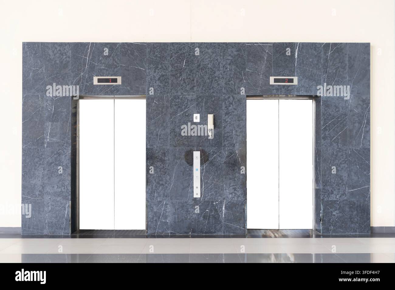 Zwillingsweiße Aufzugstüren, eingerahmt von dunklem Marmor, schaffen klaren Kopierraum für Text, Grafiken, Branding, Werbung, Präsentation, Büro, Hotel, Archit Stockfoto