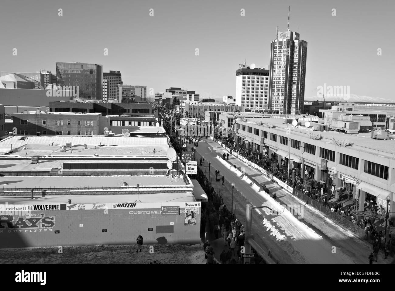Menschenmassen versammeln sich entlang einer verschneiten Innenstadtstraße zum zeremoniellen Start des Iditarod in Anchorage, Alaska. Stockfoto