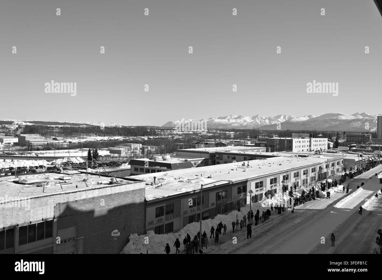 Menschenmassen versammeln sich entlang einer verschneiten Innenstadtstraße zum zeremoniellen Start des Iditarod in Anchorage, Alaska. Stockfoto
