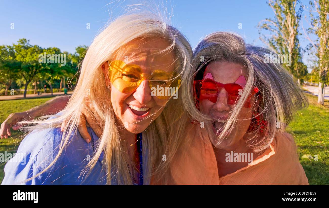 Senior-Freundinnen genießen einen fröhlichen Sommertag im Park Stockfoto