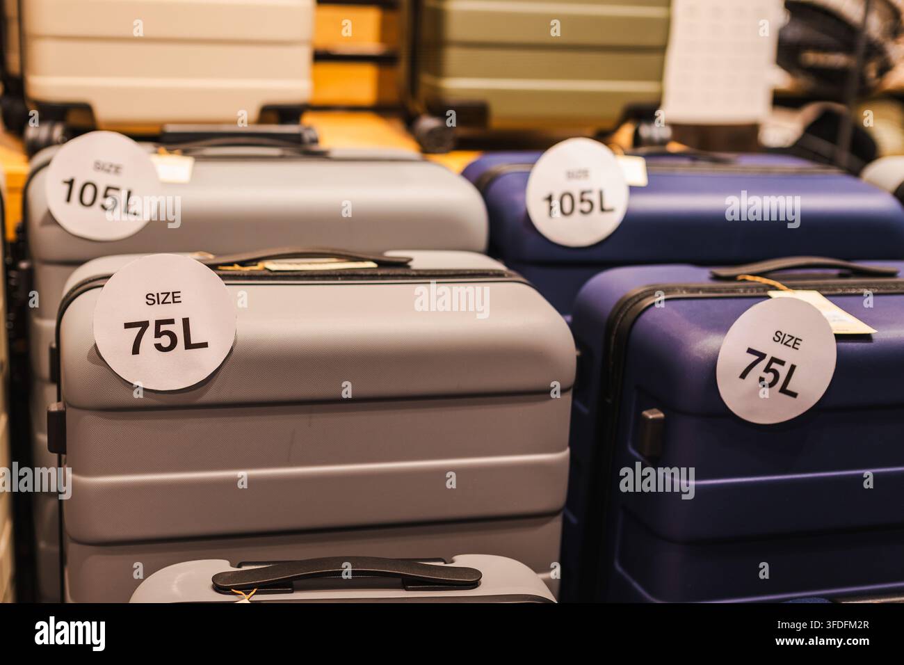 Große Hartschalenkoffer mit 75L- und 105L-Größenschildern Stockfoto