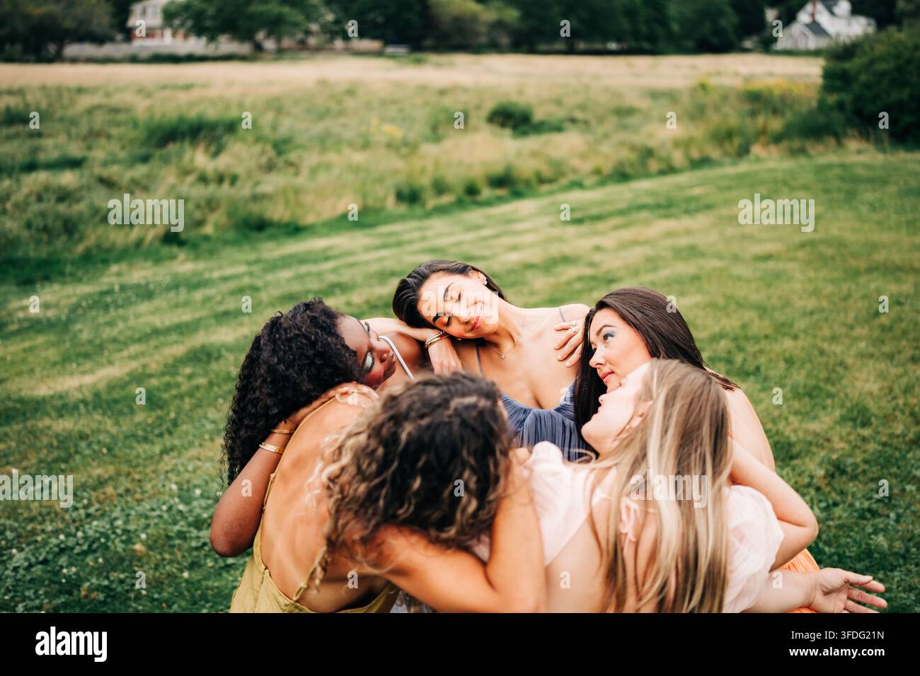 Verschiedene Freunde in einer zärtlichen Gruppenumarmung im Freien Stockfoto