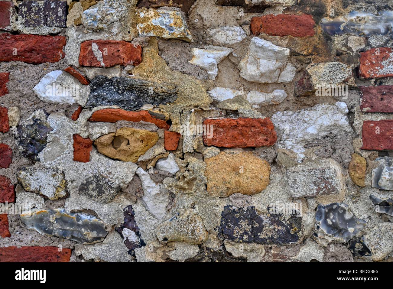 Abstrakter Hintergrunddetail der Wand eines Gebäudes an der Norfolk-Küste, hergestellt aus Ziegelstein, Kreide und Feuerstein Stockfoto